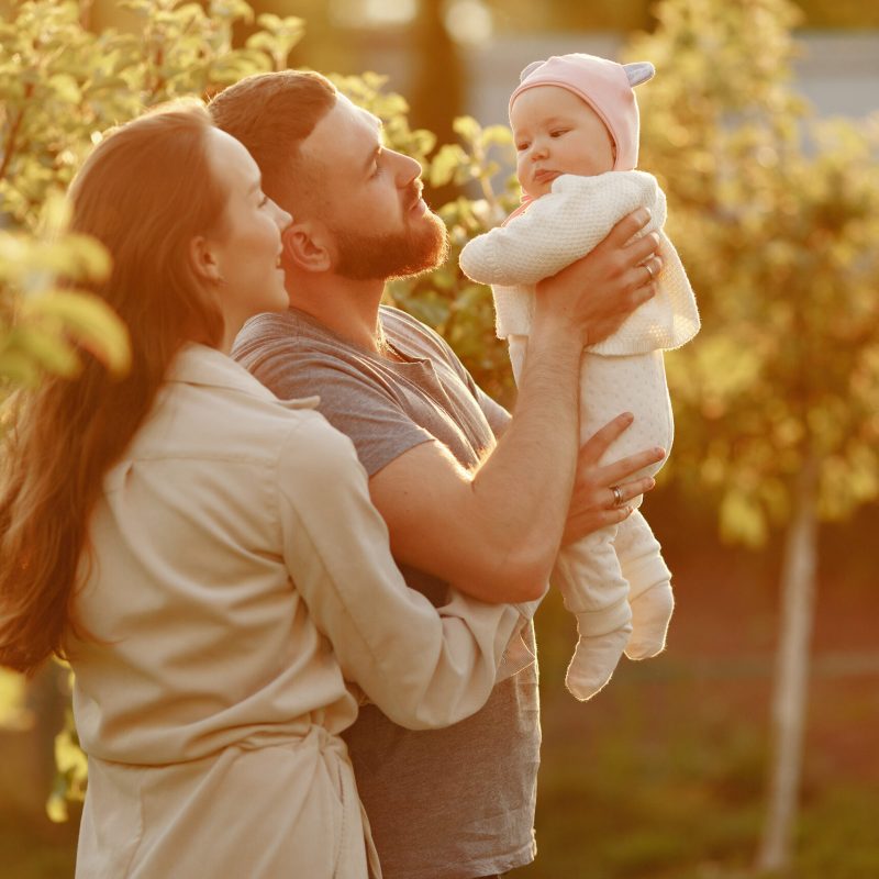 Family spend time in a summer garden Parents with daughter. Family in a park. Newborn girl.